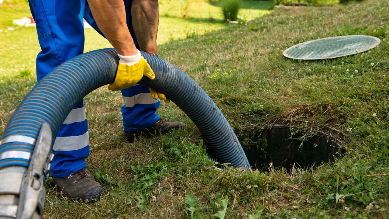 person emptying household septic tank