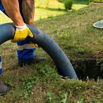 person emptying household septic tank