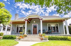 The exterior of a 1920s Craftsman bungalow home with white pillars