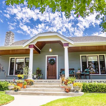 The exterior of a 1920s Craftsman bungalow home with white pillars