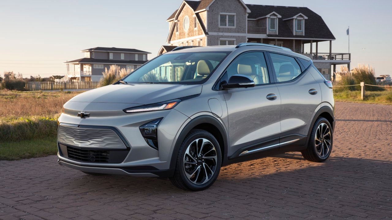 A gray 2022 Chevrolet Bolt parked in front of a coastal home