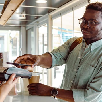 young man paying at a coffee shop