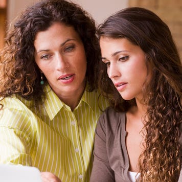 Mother and daughter look at a laptop