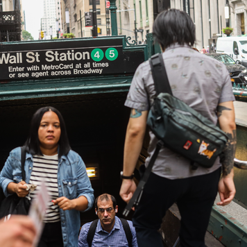 People walking out of the subway station at Wall Street
