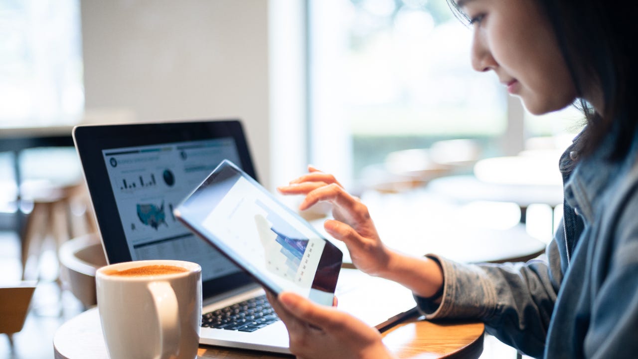 A woman looks at stock graphics on her tablet