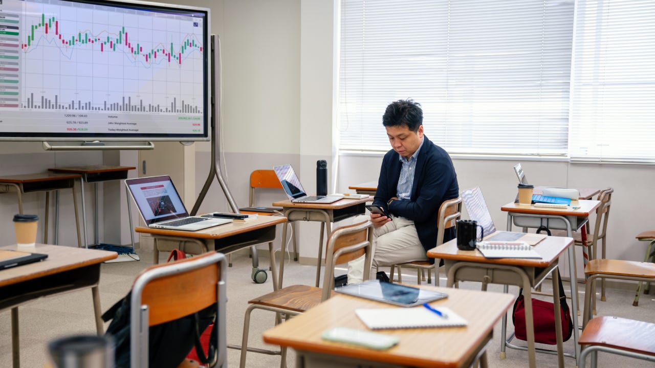 Mid adult man looking at a smart phone before or after a continuing education class