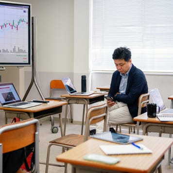 Mid adult man looking at a smart phone before or after a continuing education class