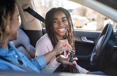 Mother handing car keys to teenage daughter