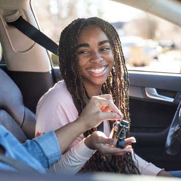 Mother handing car keys to teenage daughter
