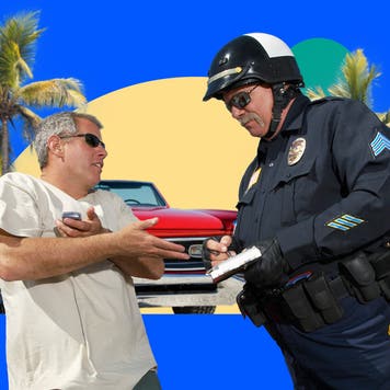 Cop writing a ticket to a driver standing outside their car