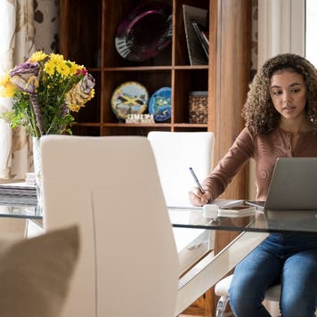 High school student fills out paperwork at a table