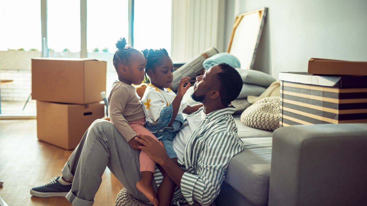 Close up of a father playing with his daughters in their new home