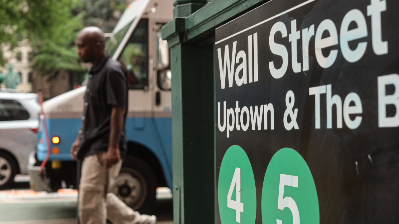 cityscape with a Wall Street sign in the foreground