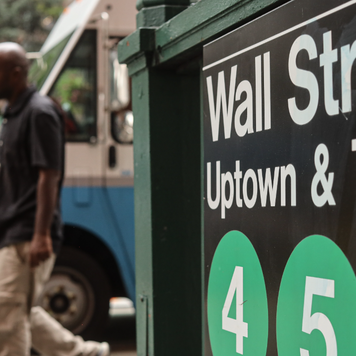 cityscape with a Wall Street sign in the foreground