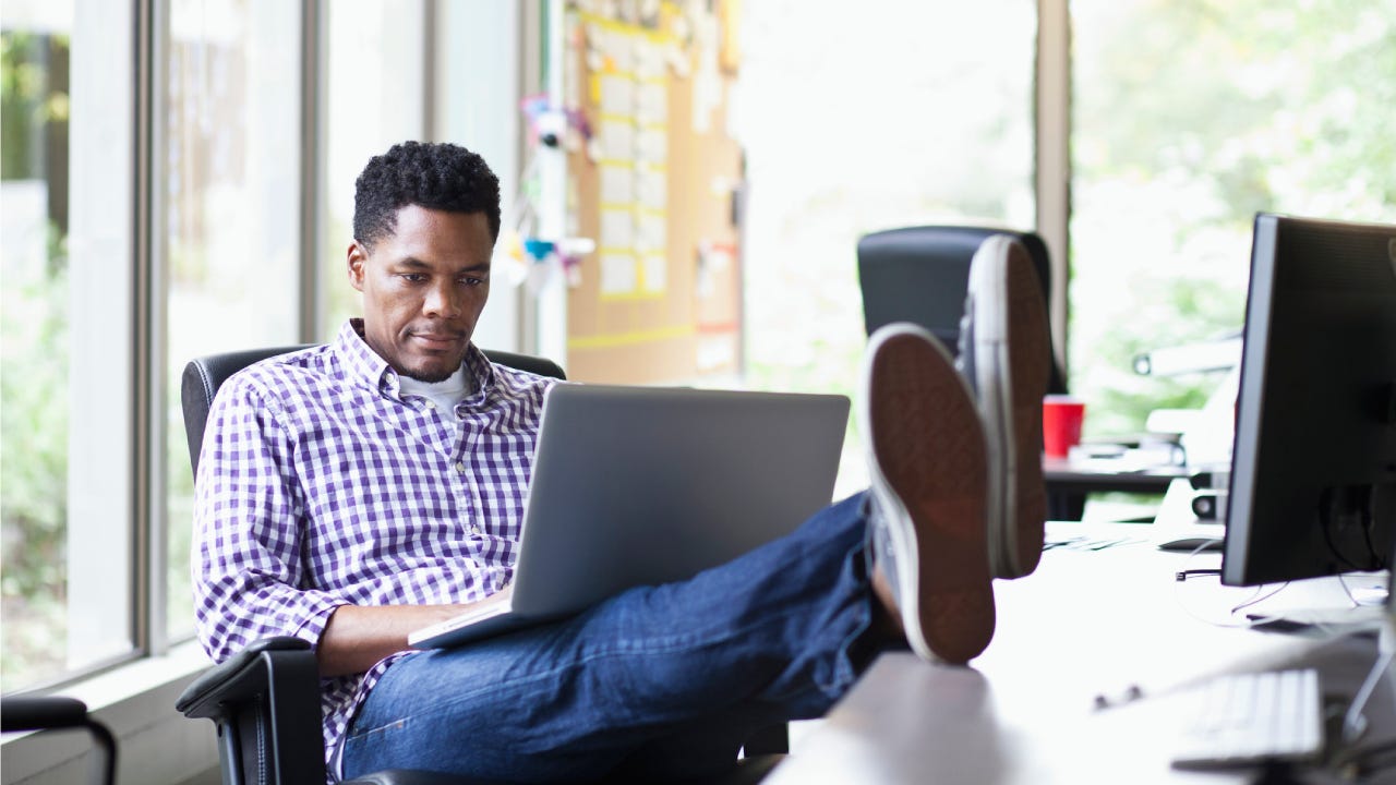 businessman working on laptop with his feet up