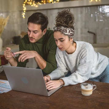 Young couple managing expenses and bills at home after holidays.