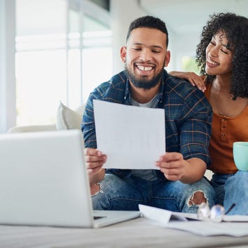 Young couple happily looking at financial documents