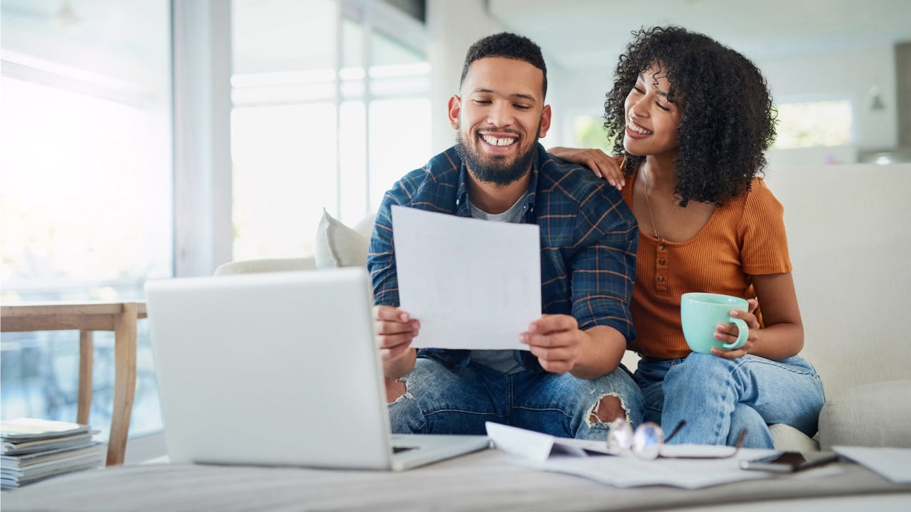 Young couple happily looking at financial documents