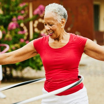 senior female dance group practicing with spinning plastic hoops in backyard