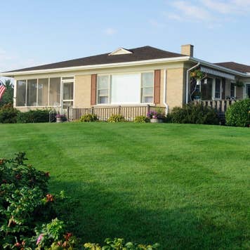 lassic american bungalow from the 60's or 70's with freshly cut lawn.