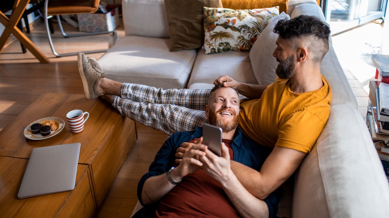 Two married men sit on the couch together