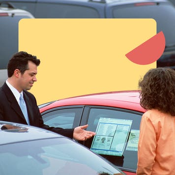 A car salesperson shows a vehicle to a buyer at a dealership.