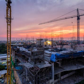 Twilight of a New Hospital Building being constructed with big crains