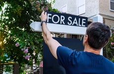 home prices dropping - realtor putting up for sale sign outside house