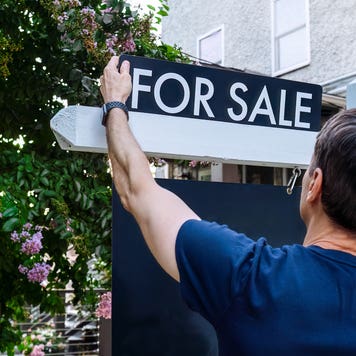 home prices dropping - realtor putting up for sale sign outside house