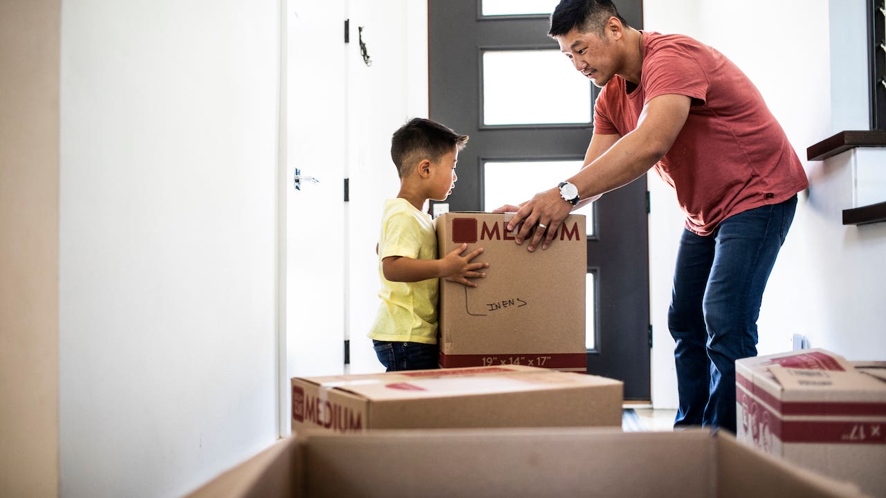 moving expenses - father and son packing moving boxes together