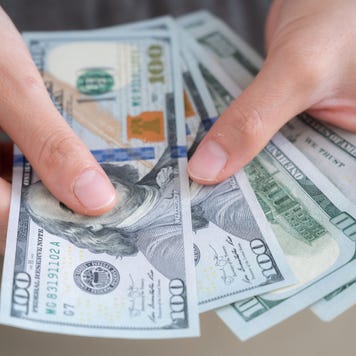 Close up of someone hands holding and counting American dollar banknotes in her hand