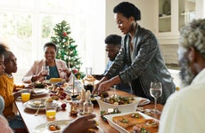 Woman serving food to friends and family during holiday celebration at home