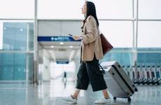 Woman walker her rolliing luggage at an airport