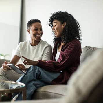 Lesbian couple at home using digital tablet