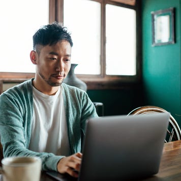 Young professional man working on a laptop in a cozy space with coffee