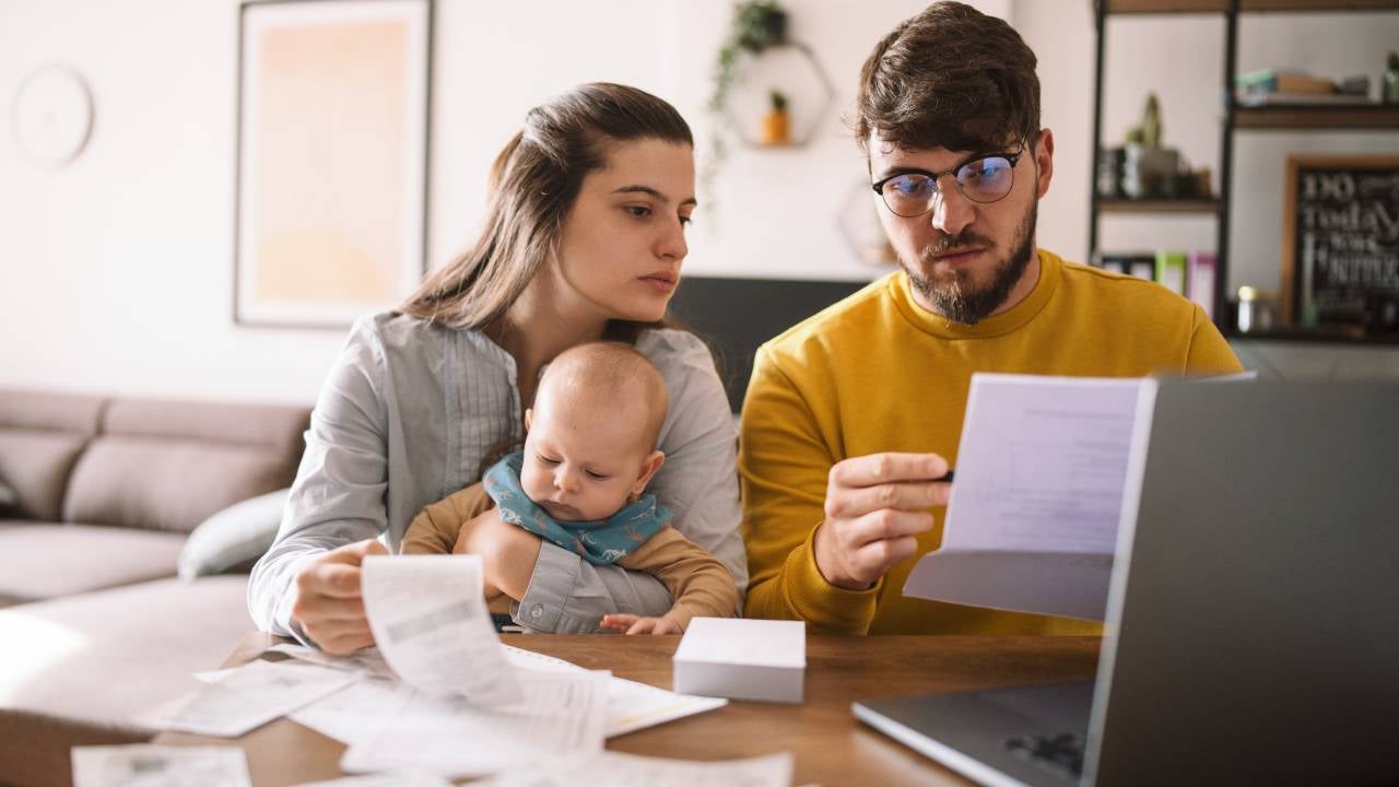 Young family with baby worried about family budget and high taxes and bills.