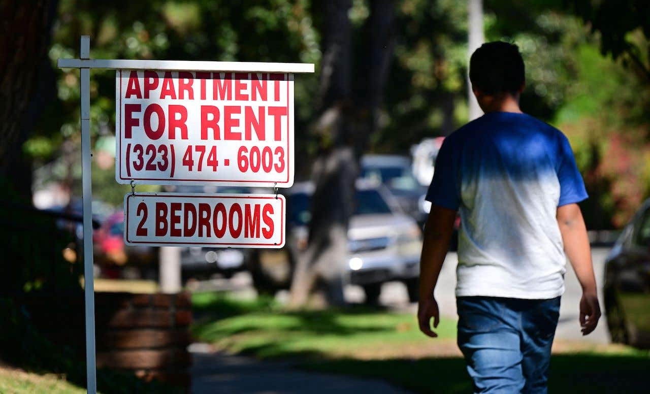 housing discrimination - man walking past "apartment for rent" sign