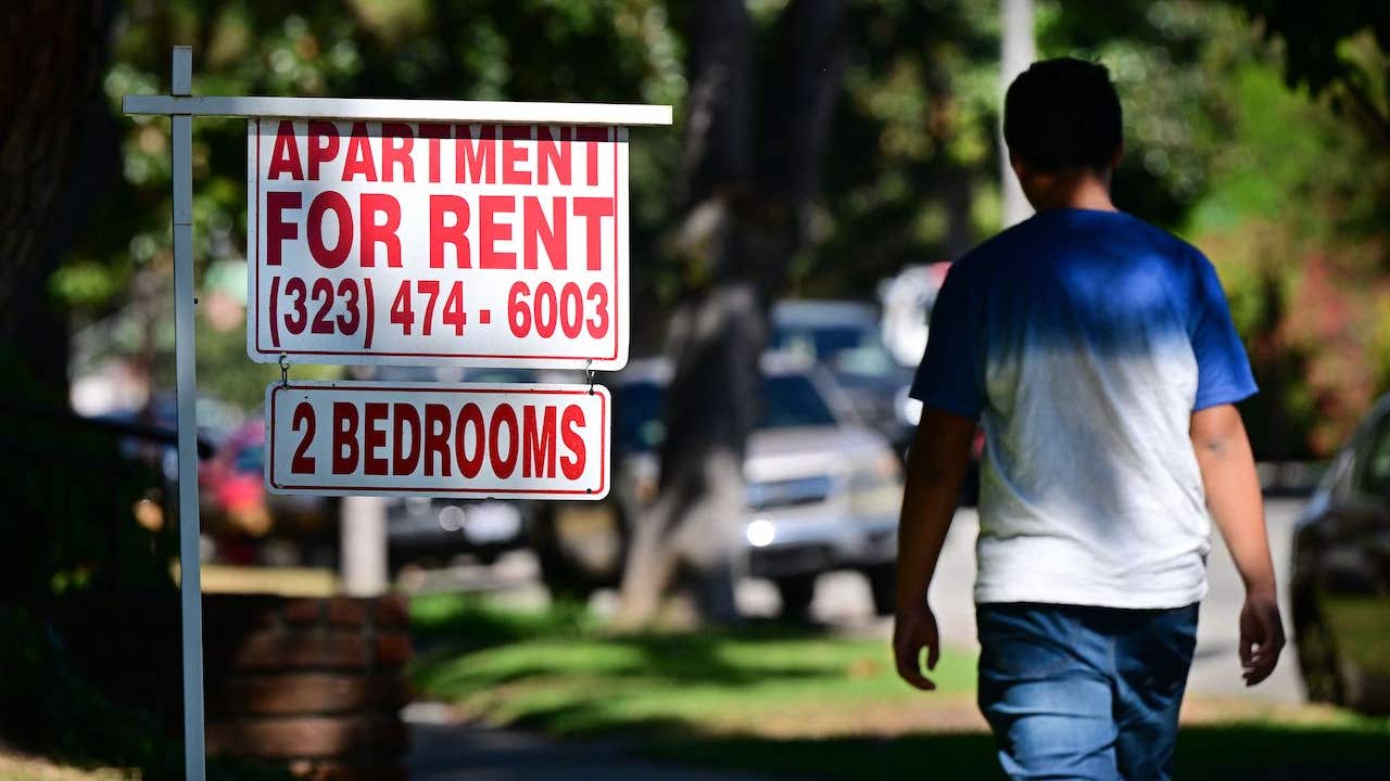 housing discrimination - man walking past "apartment for rent" sign