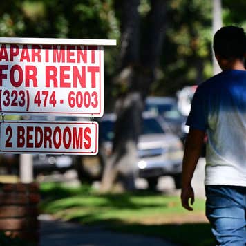 housing discrimination - man walking past "apartment for rent" sign