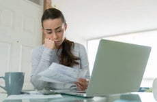 Woman paying her utility bills online and looking worried