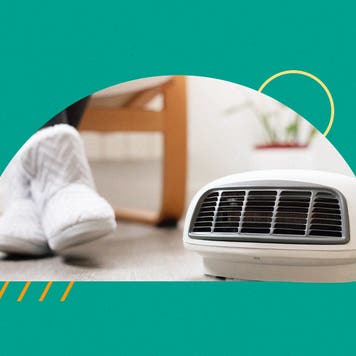 Someone sitting next to a small portal space heater.