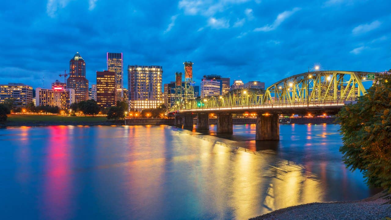 Skyline of Portland, Oregon, USA at dusk, with Willamette River and Hawthorne Bridge.