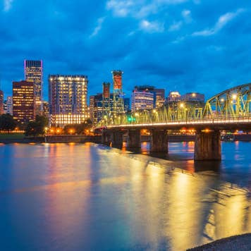 Skyline of Portland, Oregon, USA at dusk, with Willamette River and Hawthorne Bridge.