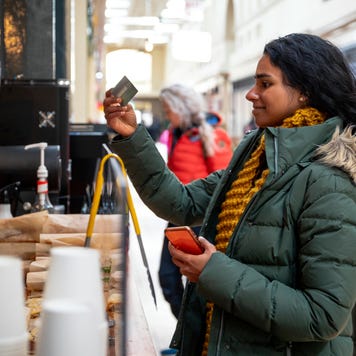 young woman paying for a coffee