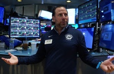 Trader on the NY Stock Exchange with his arms out and looking confused