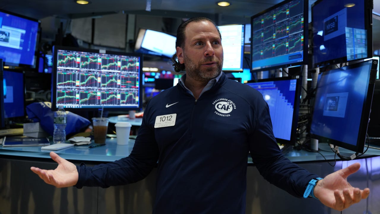 Trader on the NY Stock Exchange with his arms out and looking confused