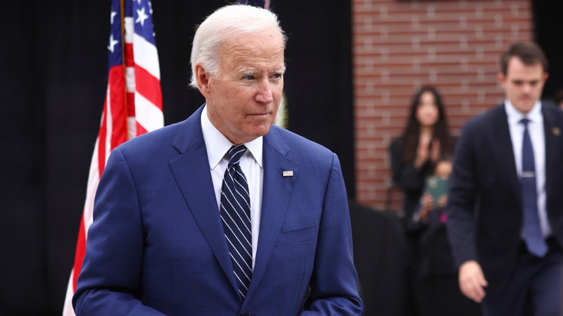 President biden walking with a flag in the background