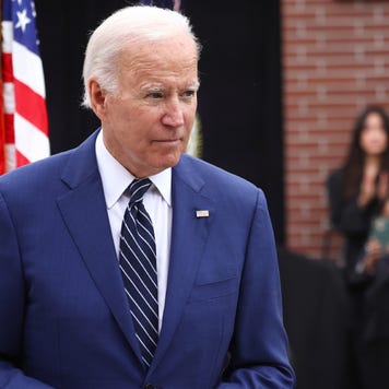President biden walking with a flag in the background