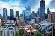 The skyscrapers of downtown Houston rise above the restored neo-classical 1910 Harris County Courthouse in downtown Houston, Texas.