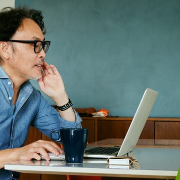 Man working on laptop with a coffee near by
